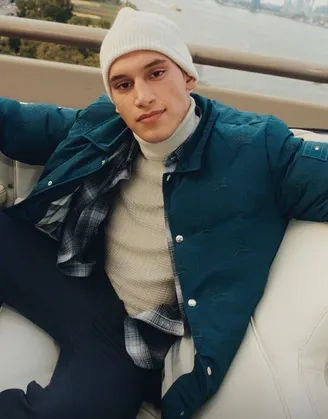 man wearing jacket sitting on couch